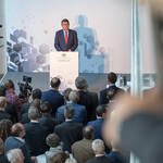Staatssekretaer Franz-Josef Schierer am Pult bei seiner Rede, Blick von der Galerie über die Hinterköpfe der Gäste
